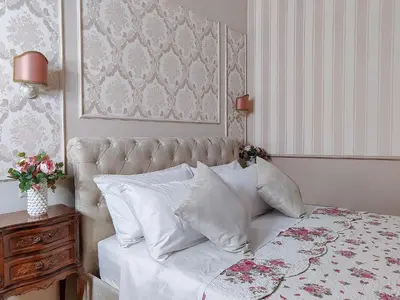 a bedroom with a bed with white sheets and pillows at Maison Bonheur in Rome