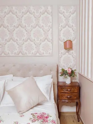 a bedroom with a bed and a table with flowers on it at Maison Bonheur in Rome