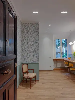 a living room with a chair and a table at Maison Bonheur in Rome