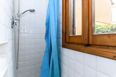a shower with a window and a blue shower curtain at Central near Piazza Navona by NDP rent in Rome