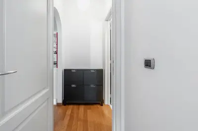 a hallway with a black dresser and a door at Portuense 107 - Bright Flat in Rome