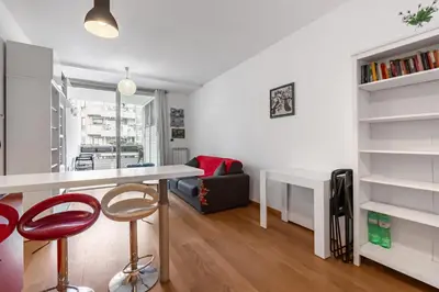 a kitchen and living room with a desk and chairs at Portuense 107 - Bright Flat in Rome