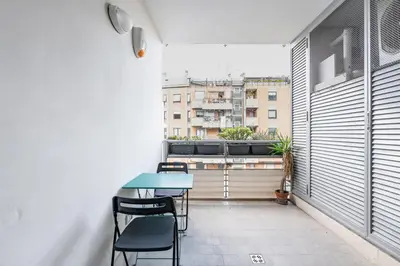 a small balcony with a blue table and chairs at Portuense 107 - Bright Flat in Rome