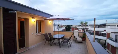 a balcony with a table and chairs and an umbrella at Cosy penthouse loft with view in Rome