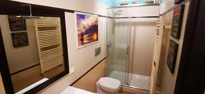 a bathroom with a glass shower and a toilet at Cosy penthouse loft with view in Rome