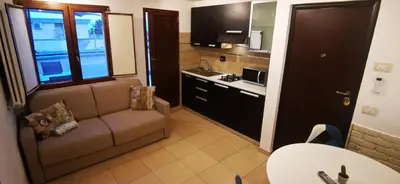 a small living room with a couch and a kitchen at Cosy penthouse loft with view in Rome