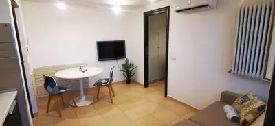 a living room with a couch and a table and a tv at Cosy penthouse loft with view in Rome