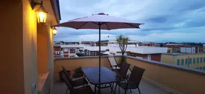 a table and chairs with an umbrella on a balcony at Cosy penthouse loft with view in Rome