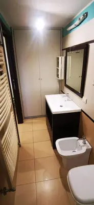 a bathroom with a sink and a toilet and a mirror at Cosy penthouse loft with view in Rome