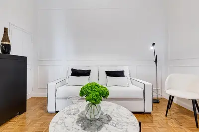 a living room with a white couch and a table at New Sistina Suite - Your Italian Holidays in Rome