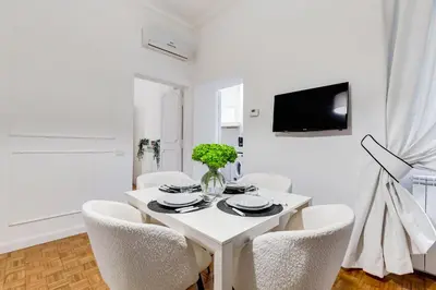 a white dining room with a white table and chairs at New Sistina Suite - Your Italian Holidays in Rome