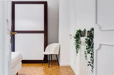 a room with a white door and a white chair at New Sistina Suite - Your Italian Holidays in Rome