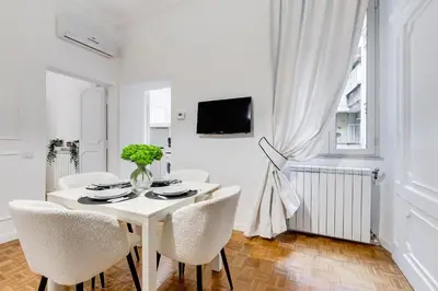 a white dining room with a white table and chairs at New Sistina Suite - Your Italian Holidays in Rome