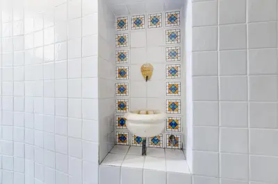 a bathroom with a sink in a tiled wall at New Sistina Suite - Your Italian Holidays in Rome