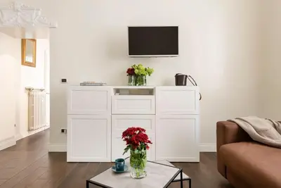 a white dresser with flowers in a living room at Luxury Blu Rome in Rome