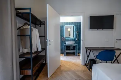 a room with a bedroom with a closet and a desk at Fantini Rooms-Monti in Rome