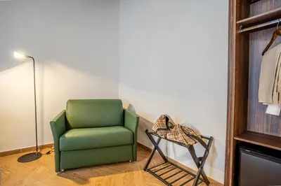 a green chair and a lamp in a room at Fantini Rooms-Monti in Rome