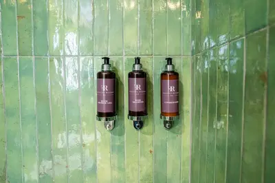 two bottles on the wall of a green tiled wall at Fantini Rooms-Monti in Rome