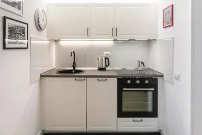 a kitchen with white cabinets and a sink and a stove at Allegra Domus in Rome
