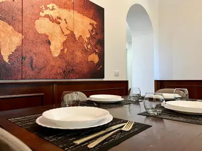 a table with plates and glasses and a map on the wall at Maison Vaticano in Rome