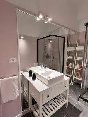 a bathroom with a white sink and a large mirror at Antinori Stresa Home in Rome
