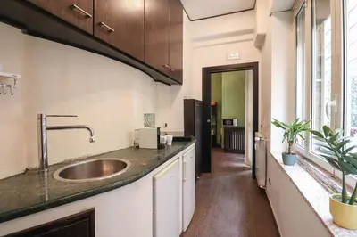 a large kitchen with a sink and a hallway at Parioli Suites Apartments in Rome