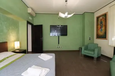 a bedroom with a bed and a tv and a chair at Parioli Suites Apartments in Rome