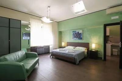a bedroom with a bed and a couch and a chair at Parioli Suites Apartments in Rome