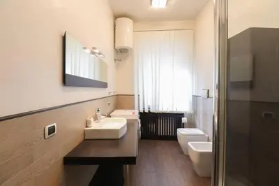 a bathroom with two sinks and a toilet and a mirror at Parioli Suites Apartments in Rome