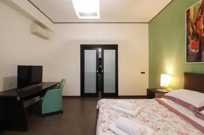 a bedroom with a bed and a desk and a computer at Parioli Suites Apartments in Rome