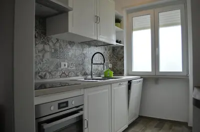 a kitchen with white cabinets and a sink at A casa di Emi e Giò in Rome