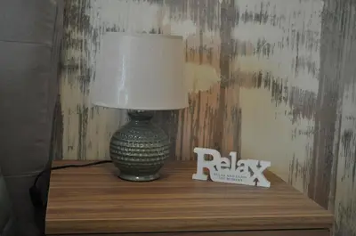 a lamp on a wooden shelf with a clock and aoku sign at A casa di Emi e Giò in Rome