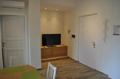 a living room with a television on a dresser and a door at A casa di Emi e Giò in Rome