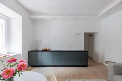 a kitchen with a black island in a white room at iFlat Vatican 2 Bedroom Design Apartment in Rome