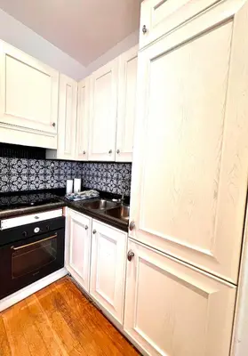 a kitchen with white cabinets and a sink at Qg Tacito 90 in Rome