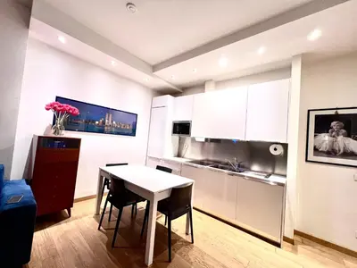 a kitchen with a white table and chairs in a room at Qg Tacito 90 in Rome
