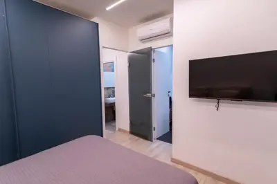 a bedroom with a bed and a flat screen tv at Living Testaccio - Modern Apartment in Rome
