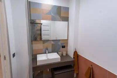 a bathroom with a sink and a mirror at Living Testaccio - Modern Apartment in Rome