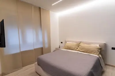 a bedroom with a bed and a tv on a wall at Living Testaccio - Modern Apartment in Rome