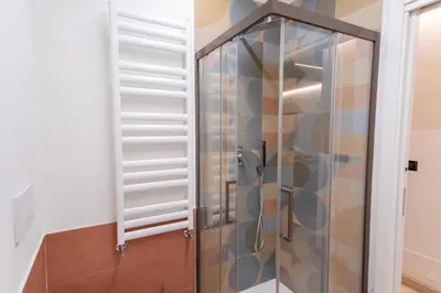 a shower with a glass door in a bathroom at Living Testaccio - Modern Apartment in Rome