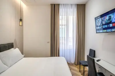 a hotel room with a bed and a flat screen tv at Vatican Eagle in Rome