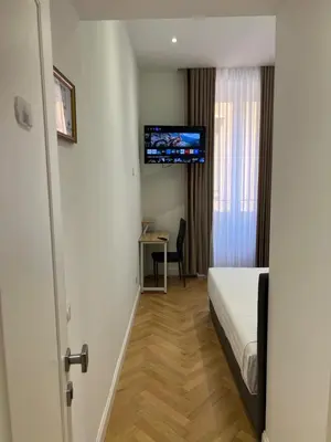 a hotel room with a bed and a desk and a television at Vatican Eagle in Rome