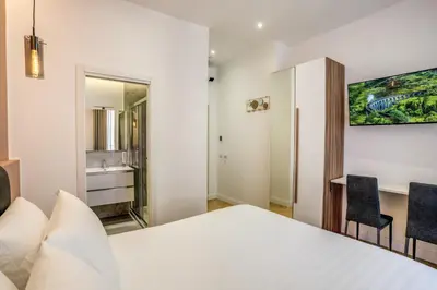 a bedroom with a bed and a desk with chairs at Vatican Eagle in Rome