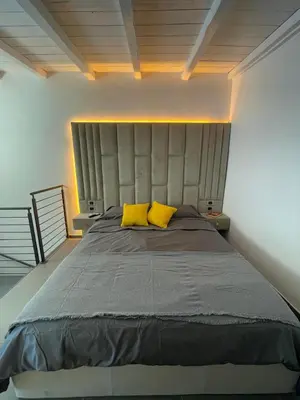 a bedroom with a large bed with two yellow pillows at JOIVY Exclusive 2-Bedroom Villa with Private Garden - 5 minutes from the Colosseum in Rome