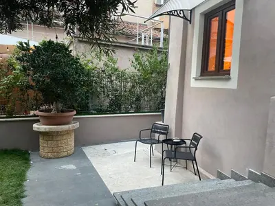 two chairs and a table in front of a house at JOIVY Exclusive 2-Bedroom Villa with Private Garden - 5 minutes from the Colosseum in Rome