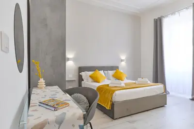 a bedroom with two beds and a table in it at Labi Home Colossevm in Rome