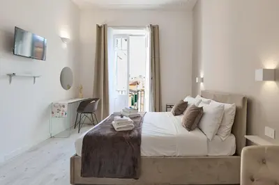 a white bedroom with a bed and a window at Labi Home Colossevm in Rome