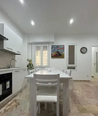 a white kitchen with a white table and chairs at A & F Apartment in Rome