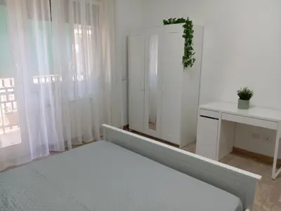a white room with a bed and a table at A & F Apartment in Rome