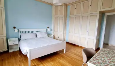 a bedroom with a white bed and a chair at Exclusive 230m2 Apt with Terrace and Panoramic Balcony in Rome